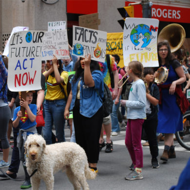 Young people marching with hand made signs: It's OUR FUTURE! ACT NOW!; Facts aren't Opinions; What's the Use of an Education if I have no Future.