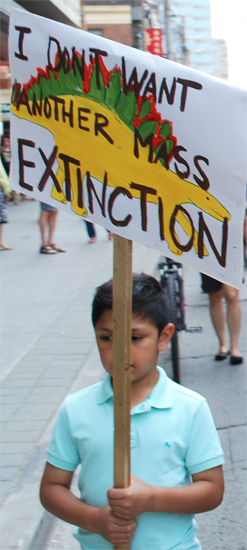 child holding sign "I don't want another mass extinction"